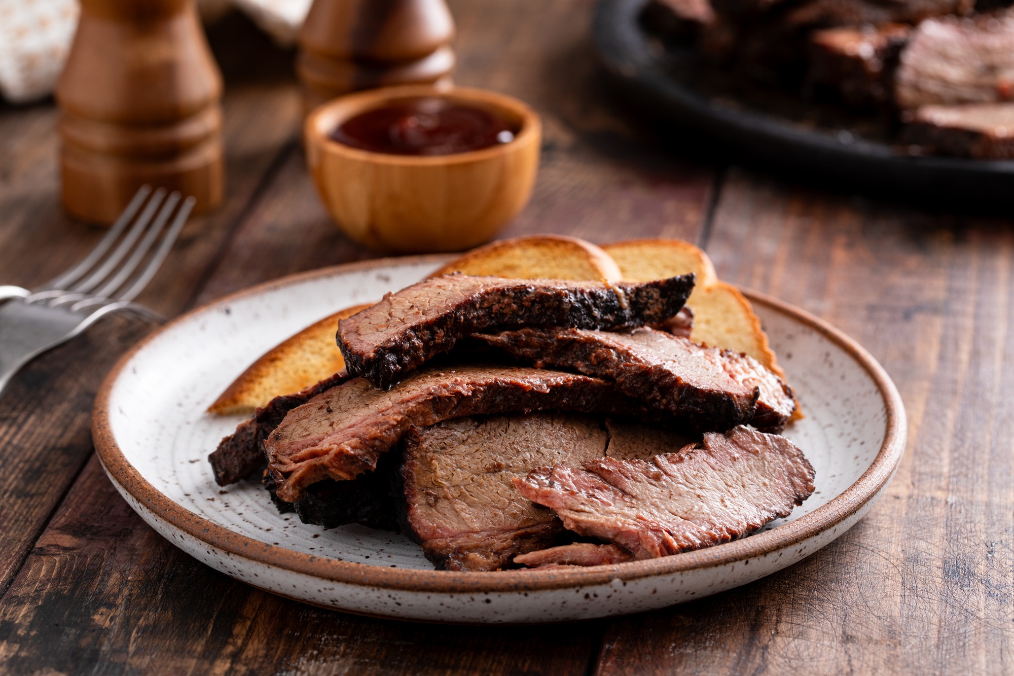 Sliced smoked brisket on a plate with toast
